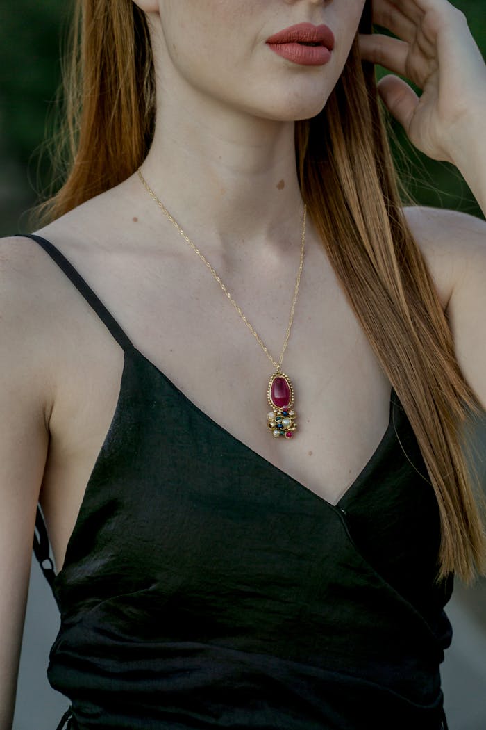 services-04 A woman wearing a stylish necklace with a vibrant gemstone pendant, showcasing fashion elegance.